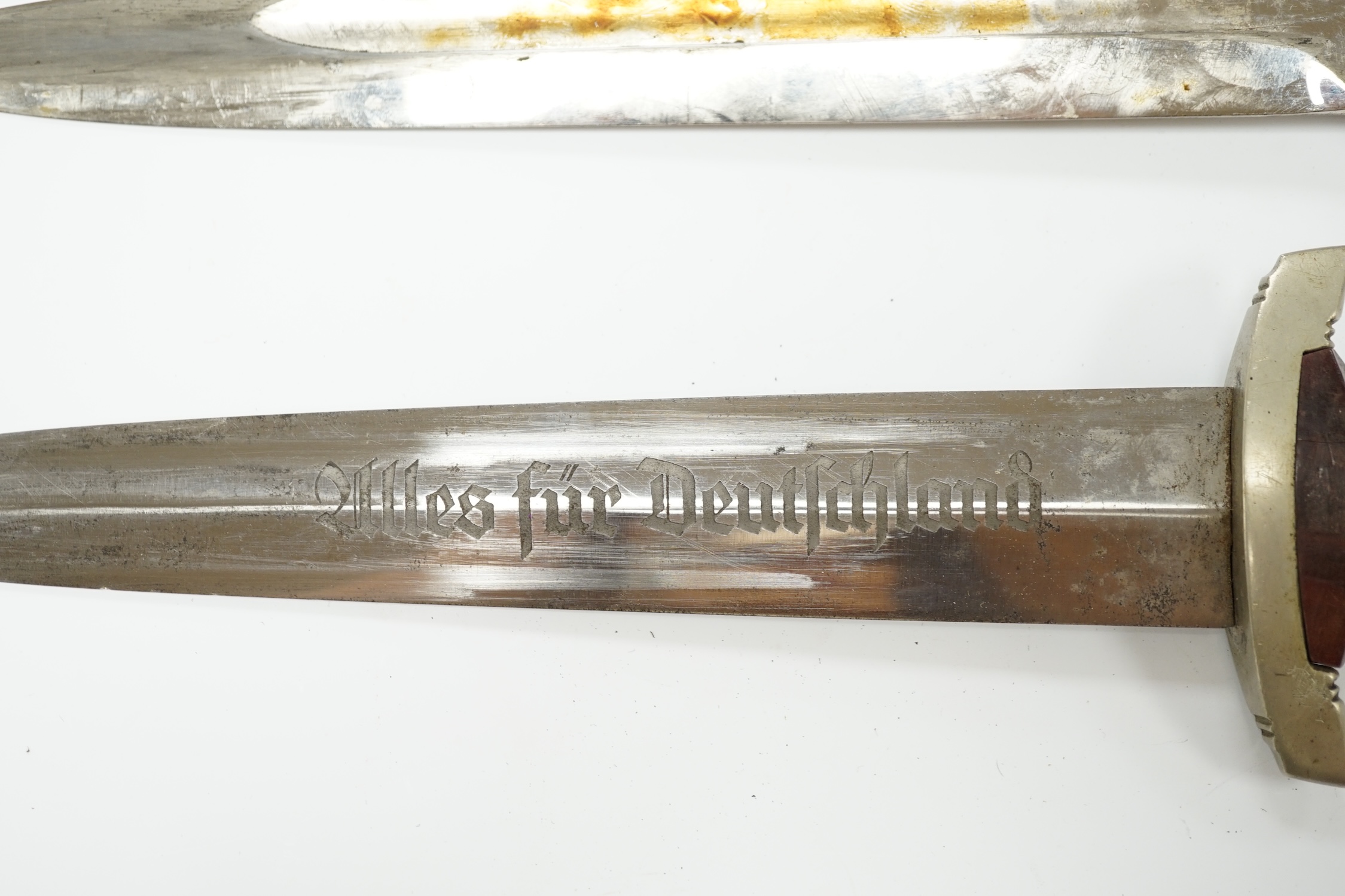 A WWII German SA dagger, regulation pattern in its steel scabbard with regulation nickel mounts, and leather hanging band and a German dress bayonet by Paul Seilheimer. Condition - fair, some wear